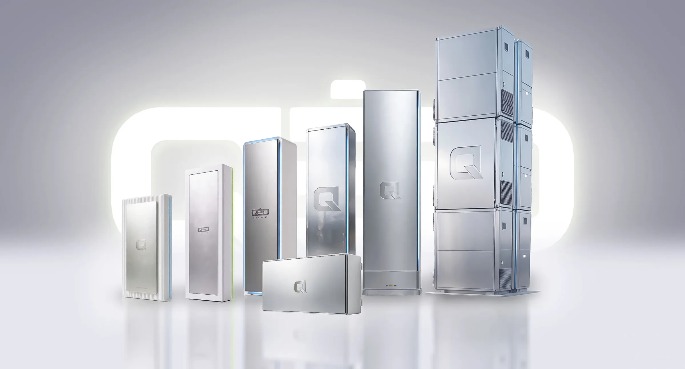 The QED range side by side, from a compact wall unit to a stacked tower, in front of a glowing QED mark, concept render