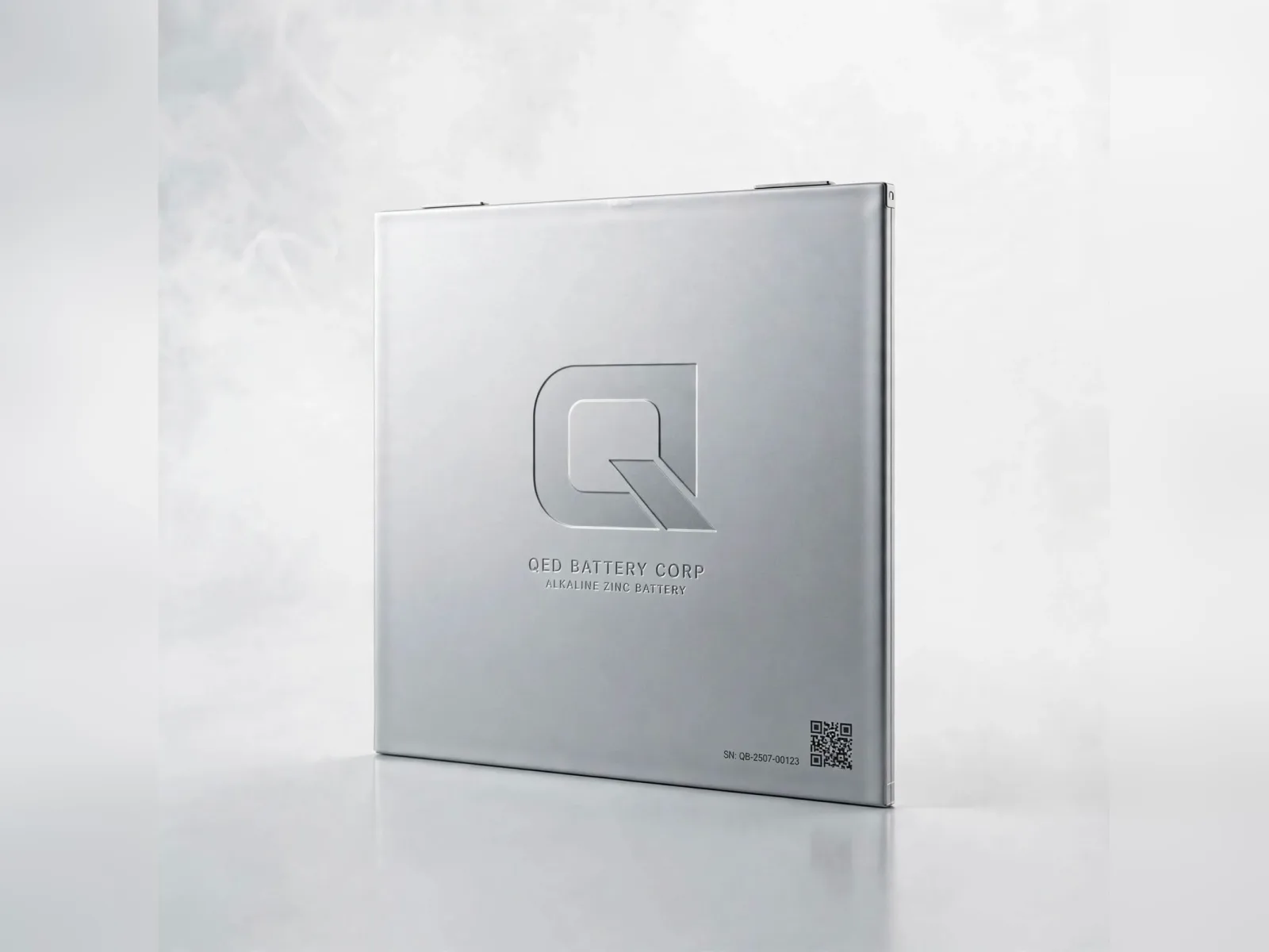 A flat prismatic QED cell in brushed aluminium, the Q mark embossed on its face, concept render